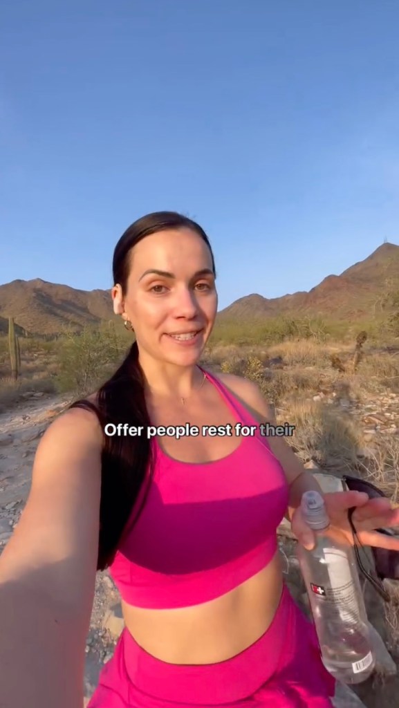 Woman in pink athletic wear hiking in a desert landscape.