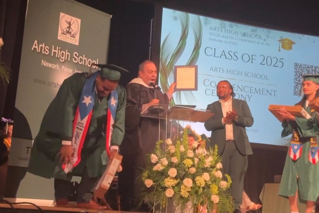 A graduate receives a job offer at Arts High School's graduation ceremony.