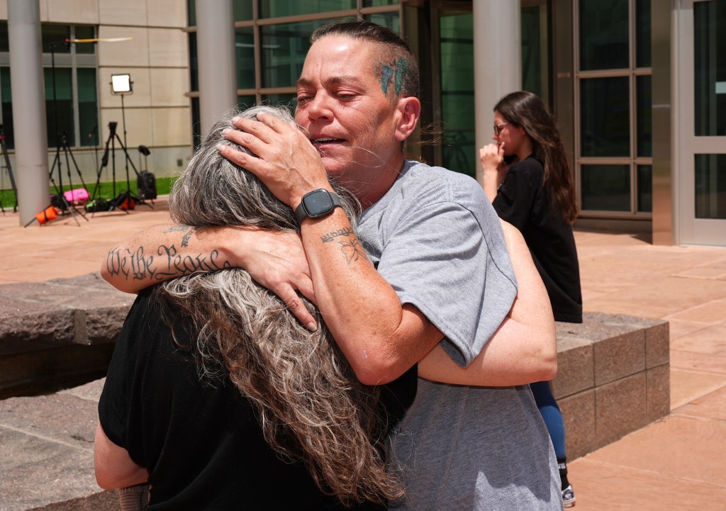 Two women embracing outside a courthouse.