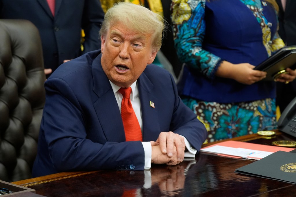 Donald Trump speaking at a table.