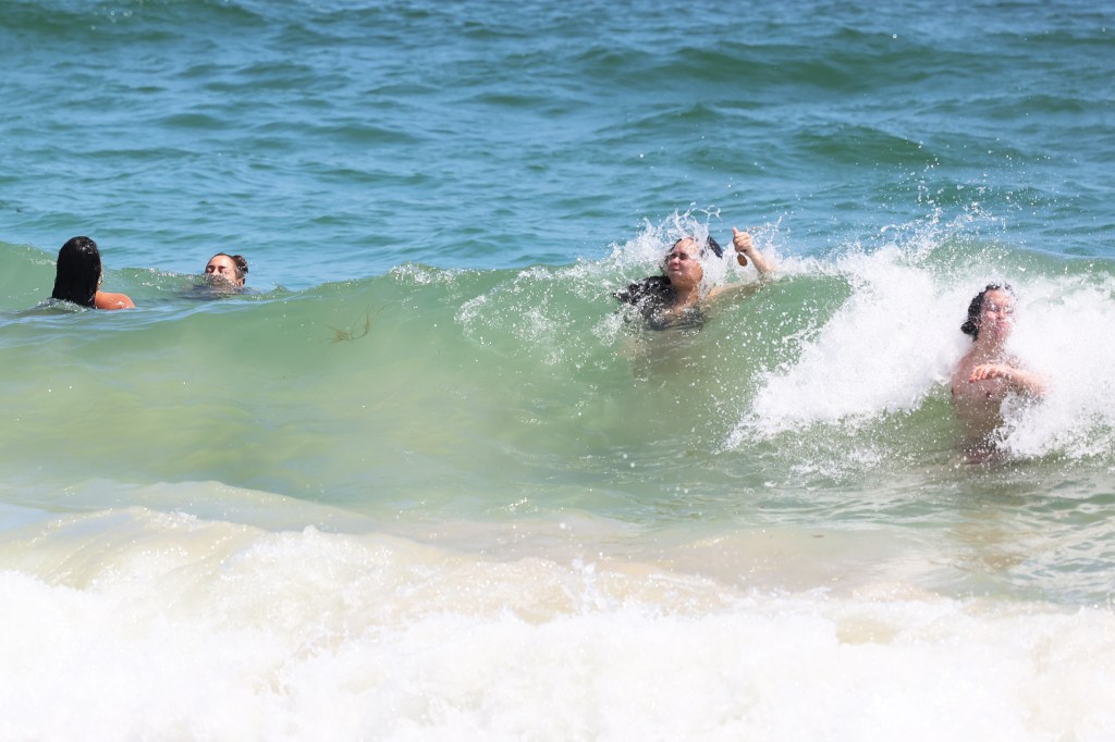 People swimming in ocean waves.