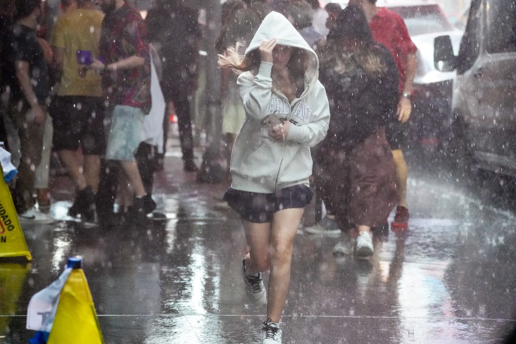 Person running through heavy rain in Times Square, NYC.