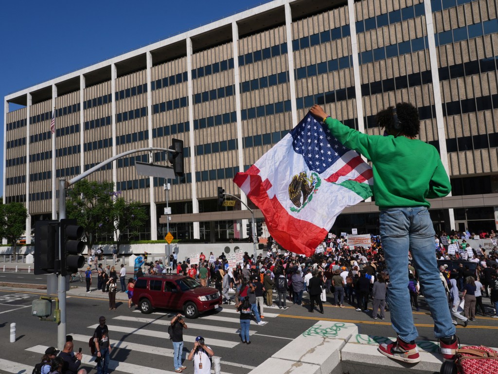 A protester holds an American and Mexican flag outside the Federal Building in Los Angeles during a rally on June 6, 2025.