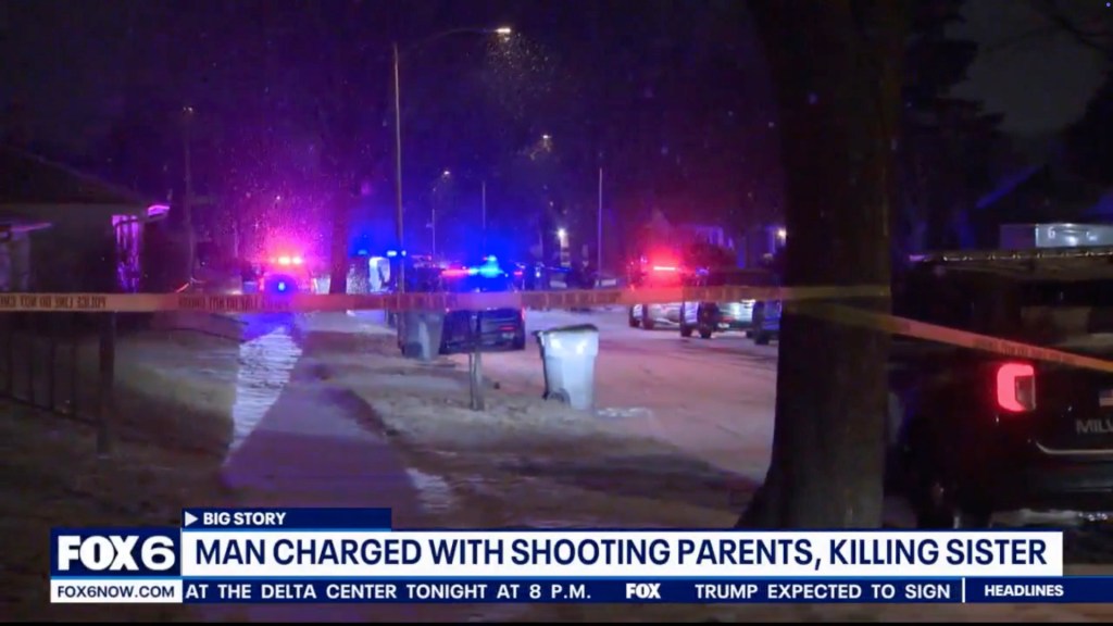 Crime scene at the Milwaukee home at night with police cars and caution tape following the triple shooting. 