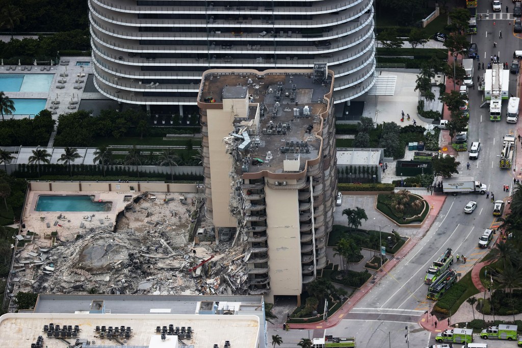 Aerial view of a partially collapsed residential building in Miami, with emergency responders on the scene.