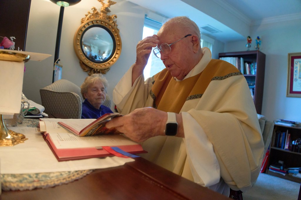 A 100-year-old priest reading.