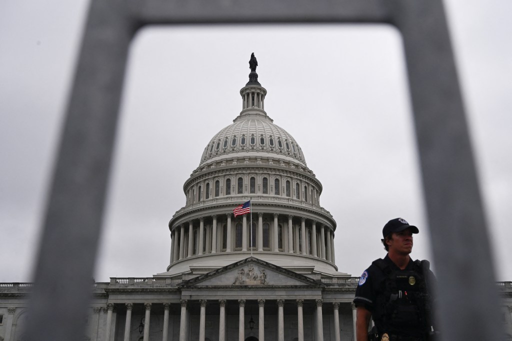 US Capitol building with a Capitol Police officer in the foreground.
