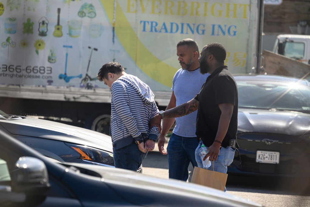 A man in handcuffs being escorted by two fire marshals.