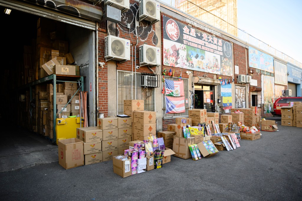 Seized illegal fireworks displayed in a warehouse parking lot.