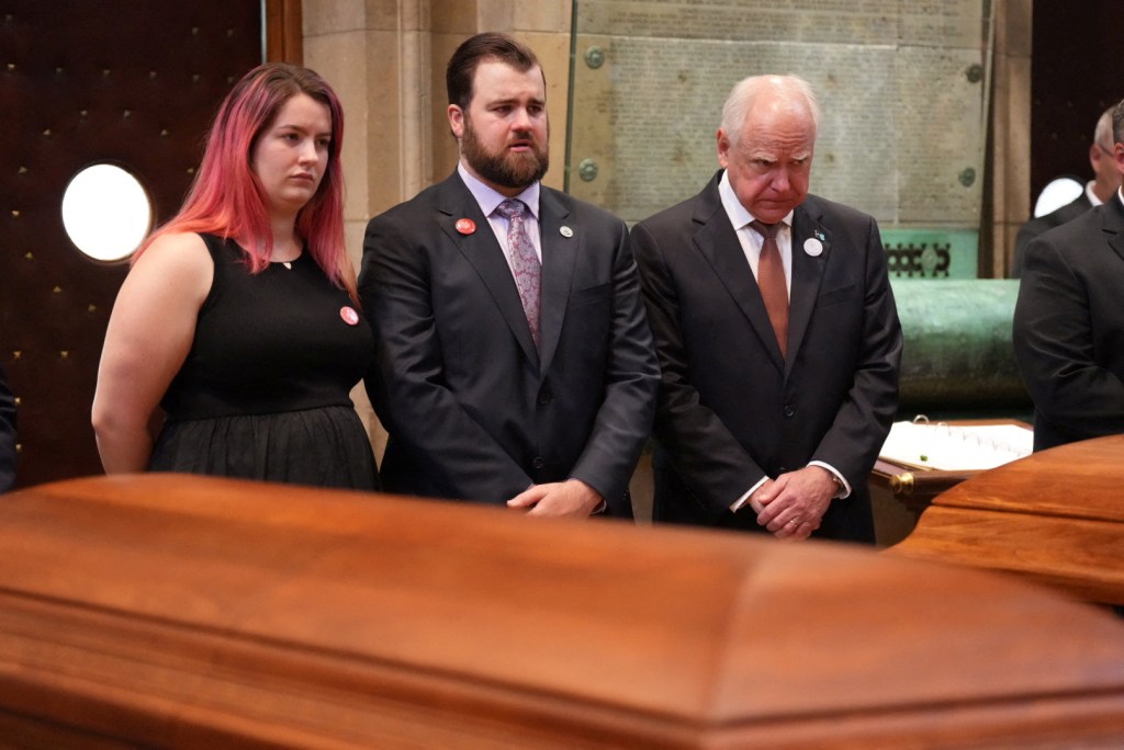 Funeral service for Minnesota lawmaker Melissa Hortman and her husband. Photo of Tim Walz and the Hortman's two children Colin and Sophie. 