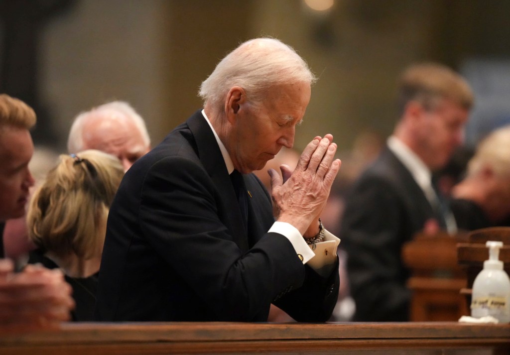 President Biden praying at the funeral.