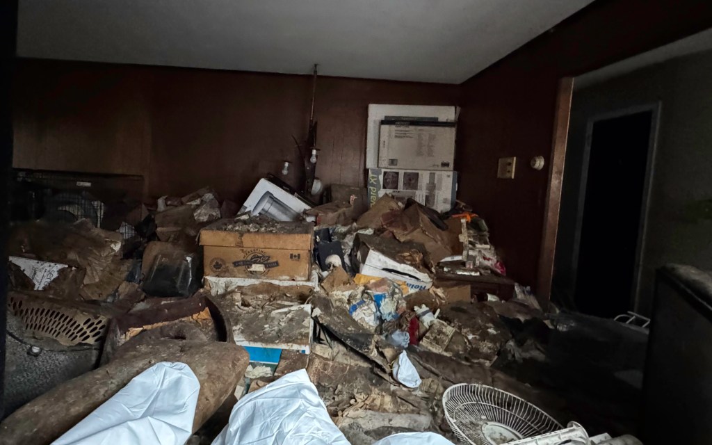 A severely cluttered room filled with debris and boxes inside of the Mill Basin home where an elderly woman was found dead and more than 100 dogs neglected on June 27, 2025