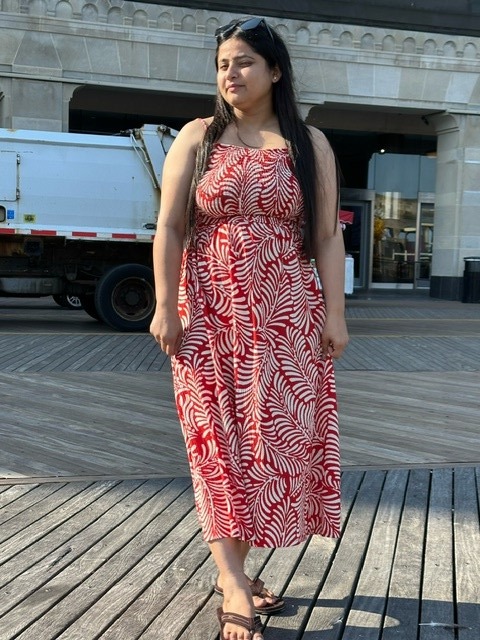 Photo of Simran, a 24-year-old woman, wearing a red and white dress.