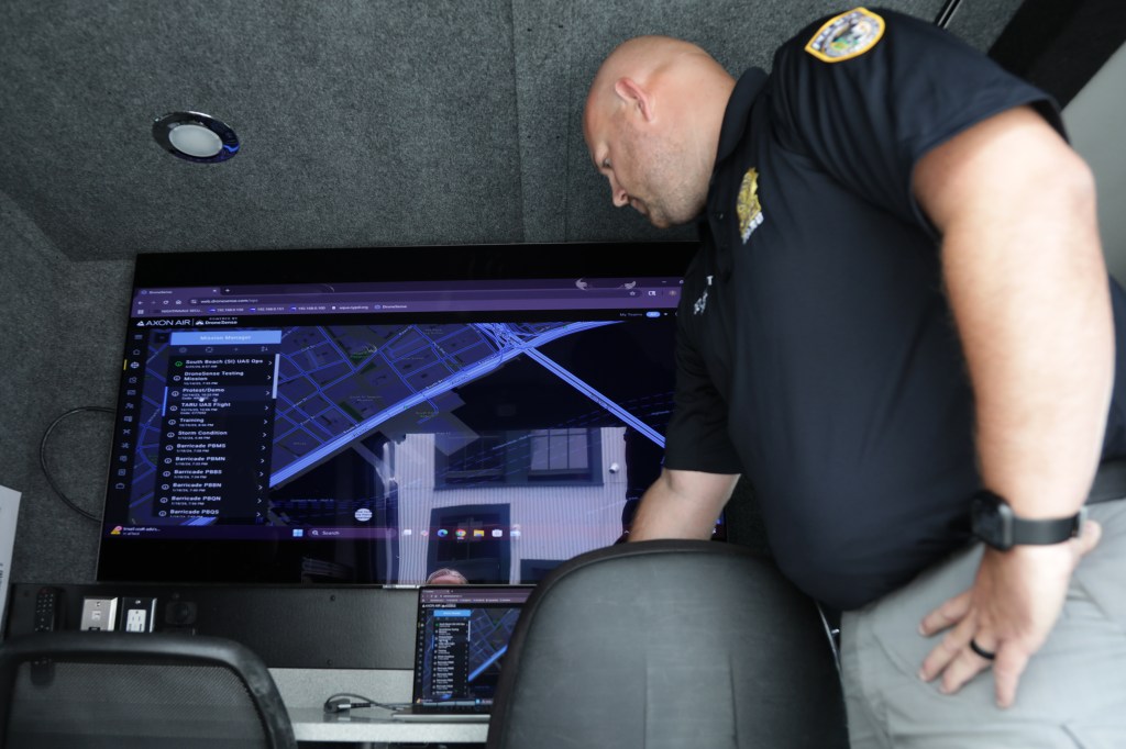 NYPD officer reviewing map on a computer screen.