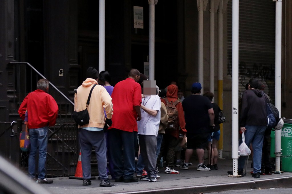 People lining up outside a clinic.