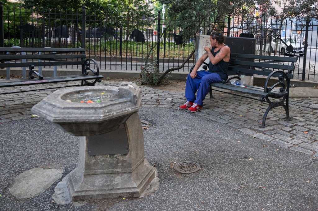 Man sitting on a park bench smoking.