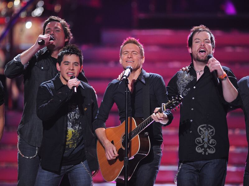 David Archuleta and David Cook perform on stage with musician Bryan Adams at the American Idol Season 7 Grand Finale.
