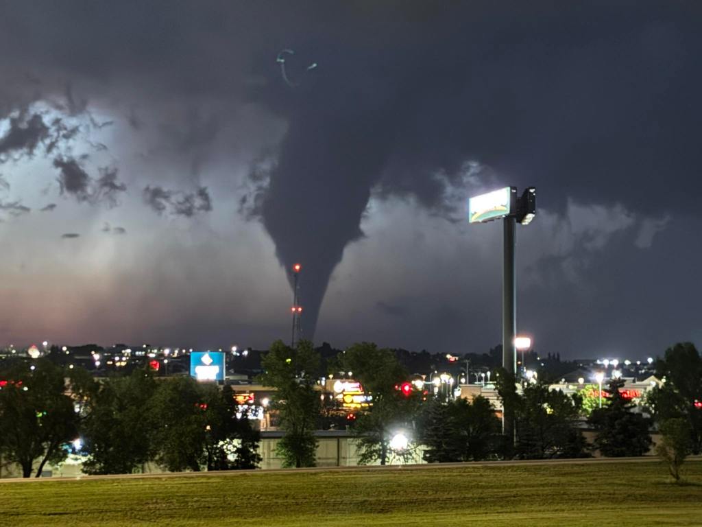 Tornado over a city at night.