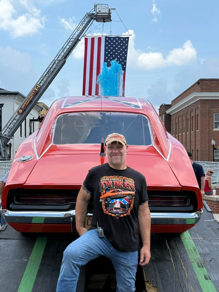 Man standing in front of a General Lee replica car.