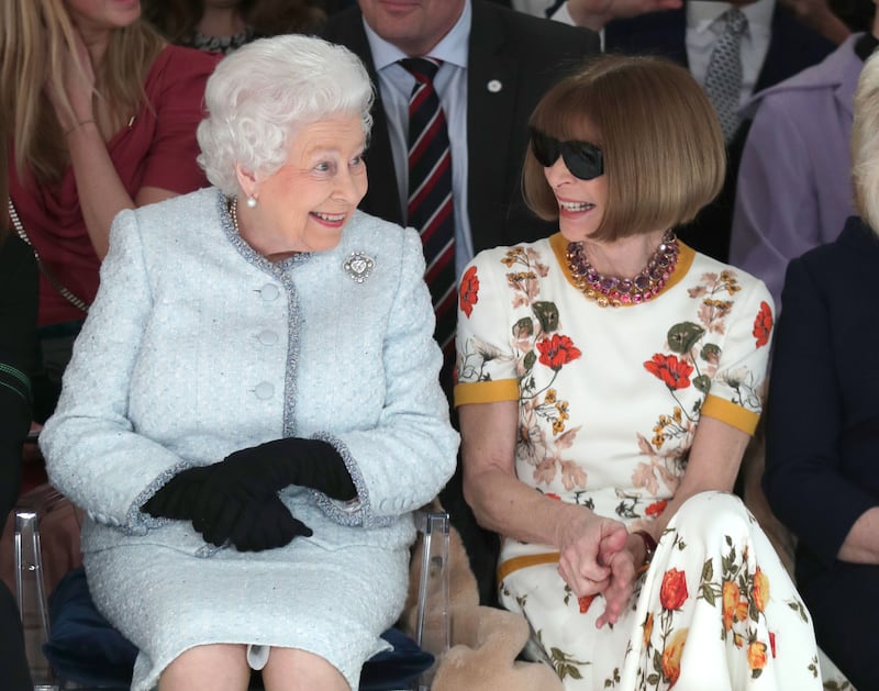 Queen Elizabeth II sits next to Anna Wintour as they view Richard Quinn's runway show before presenting him with the inaugural Queen Elizabeth II Award for British Design as she visits London Fashion Week's BFC Show Space on Feb. 20, 2018 in London, United Kingdom.