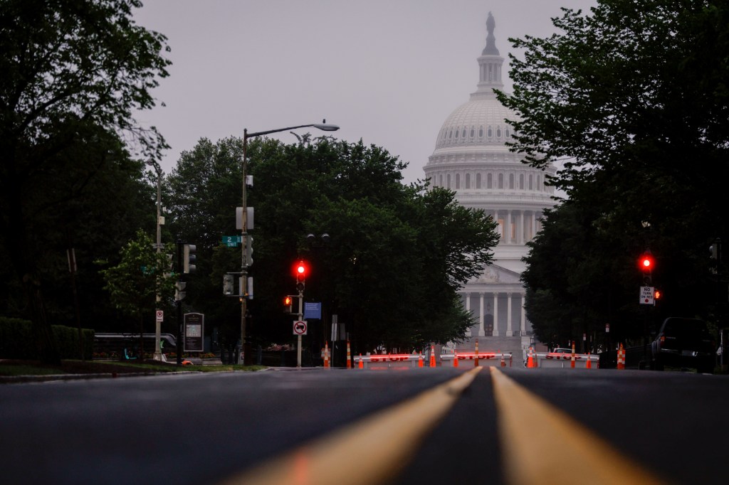 US Capitol building viewed from a street blocked by barricades.
