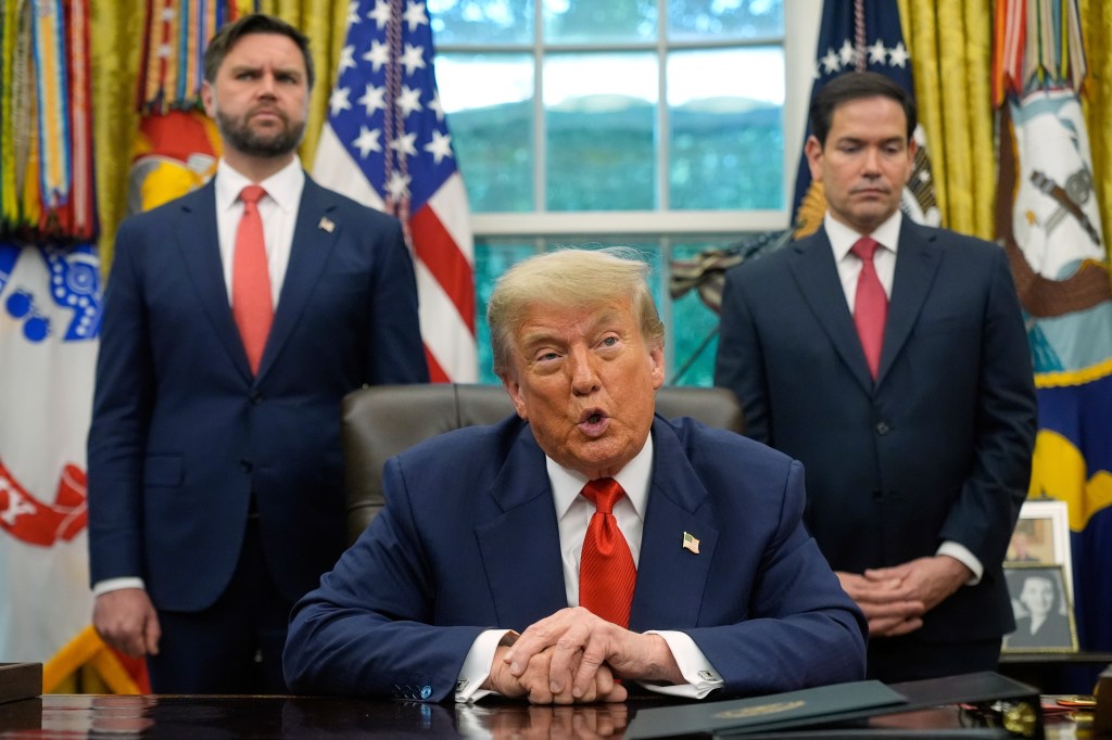 Donald Trump speaking at a press conference with two aides.