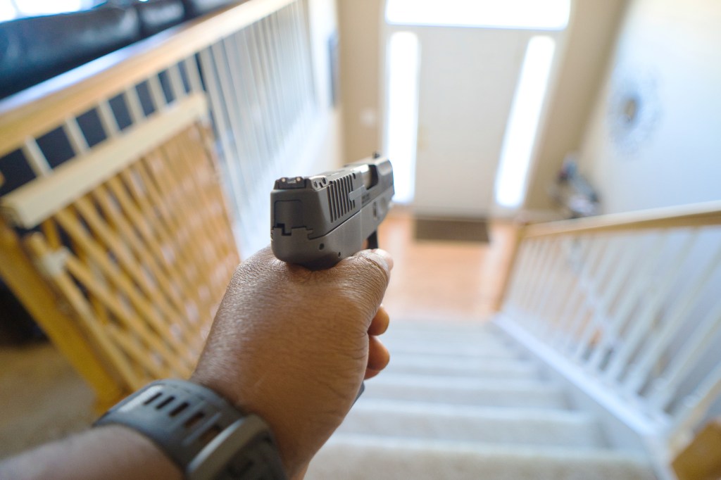 Illustration of a person holding a handgun in a home.
