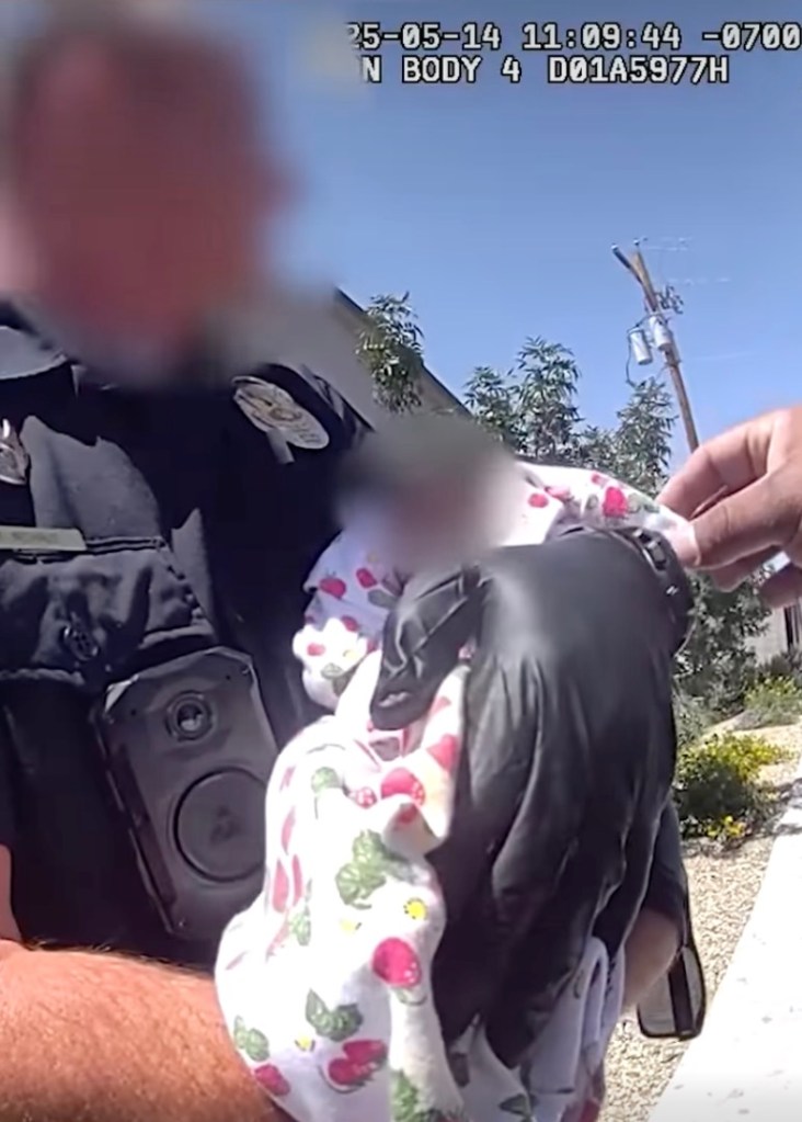 Police officer holding a baby.