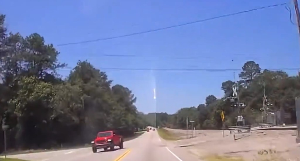 Dashcam footage of a meteor streaking across the sky.