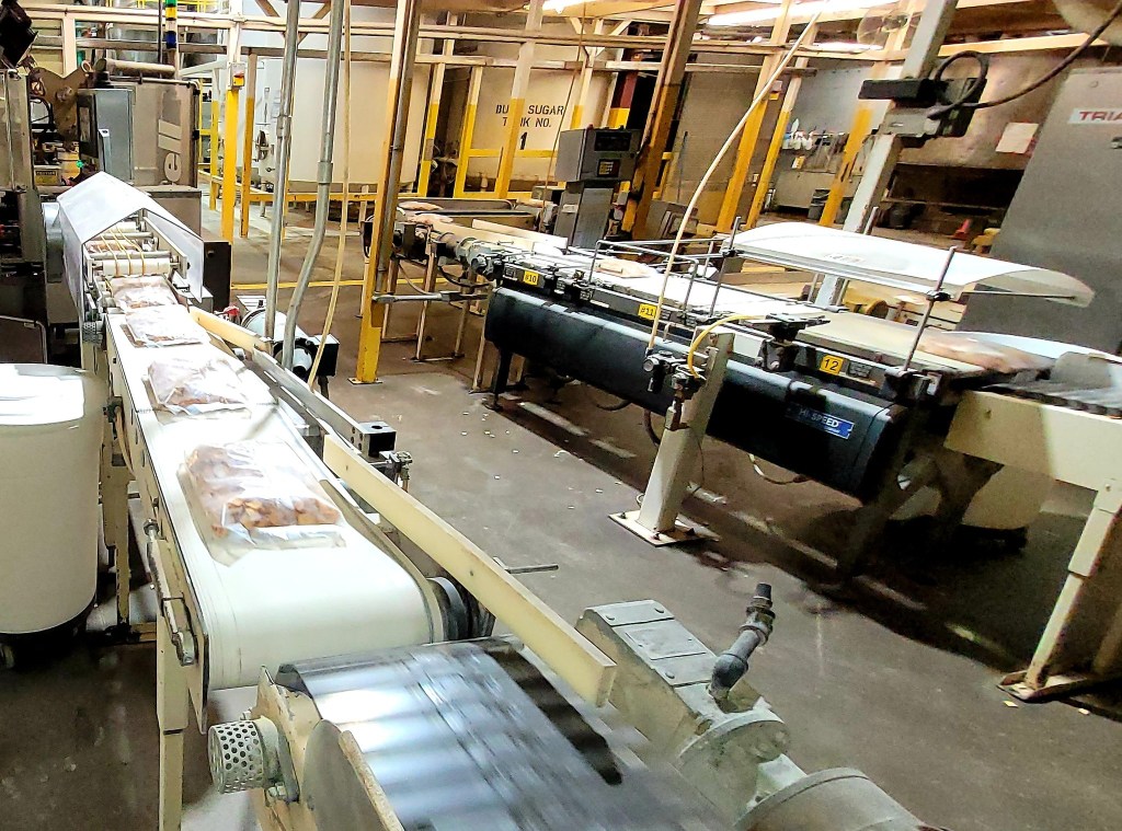 Factory conveyor belt carrying packaged food products.