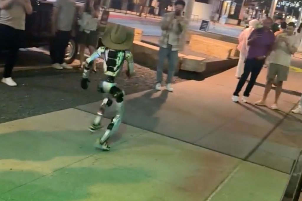 Robot in cowboy hat walking down Austin street.