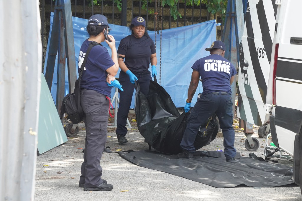 New York City Office of Chief Medical Examiner personnel removing a body bag.
