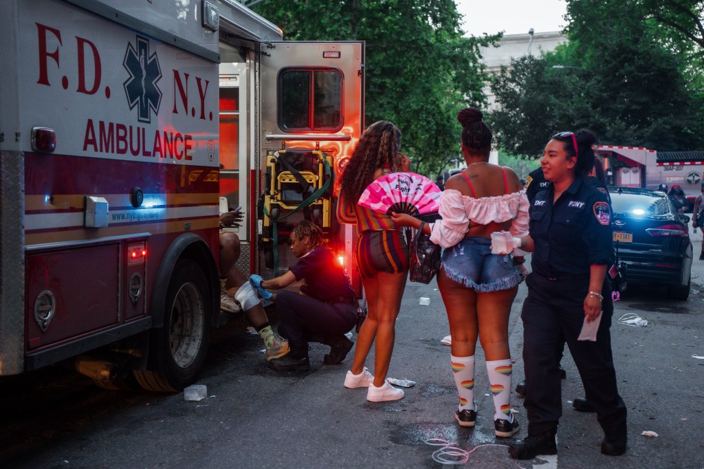 A person receiving medical attention from an FDNY EMT at the New York Pride parade.
