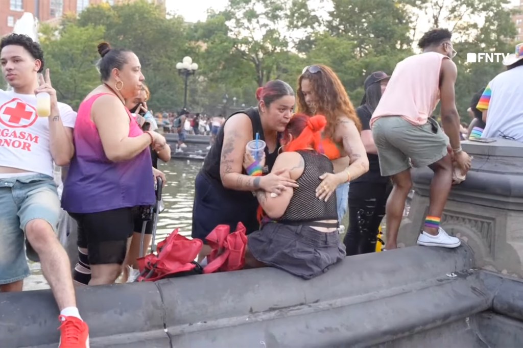 People embracing near a fountain.
