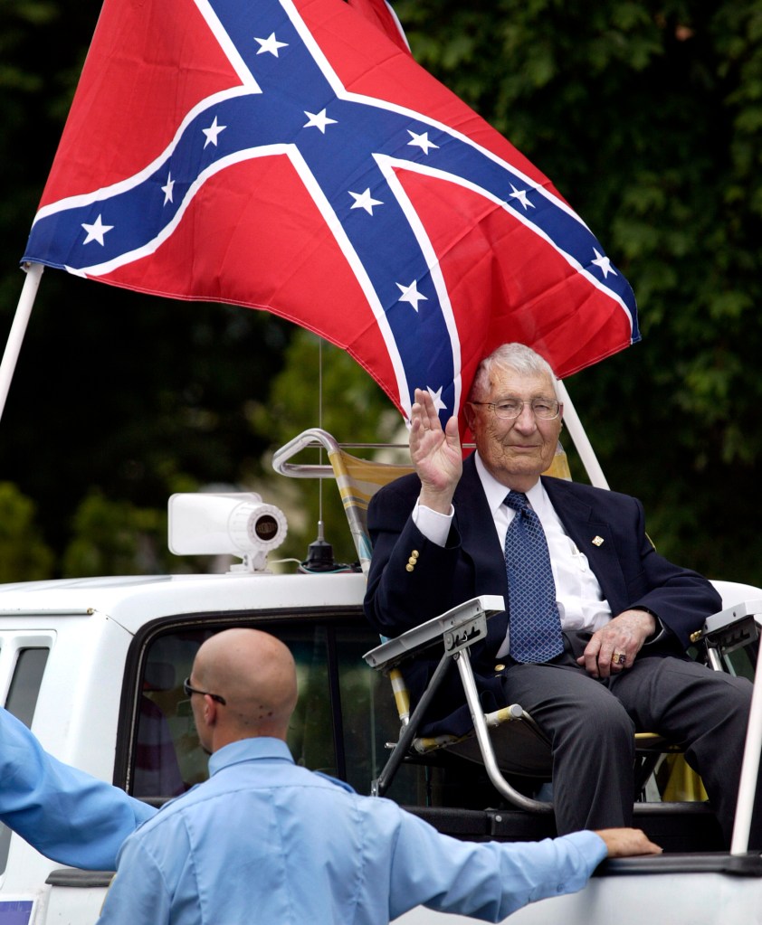 Richard Butler, leader of the Aryan Nations, waving from a truck during a parade.