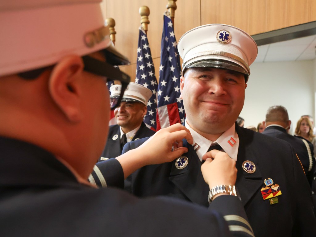 FDNY Captain Jonathan Rivera having his badge pinned on.