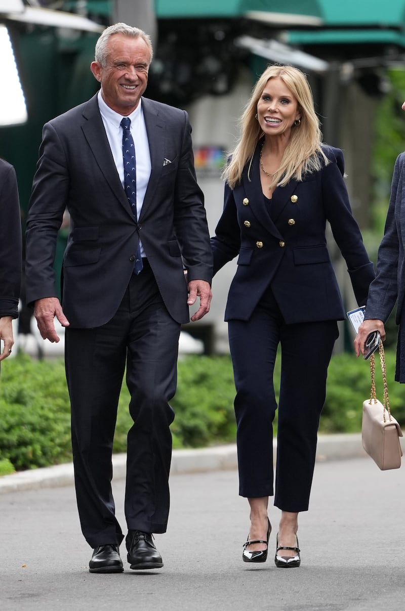 Kennedy and his wife Cheryl Hines walk together at the White House.