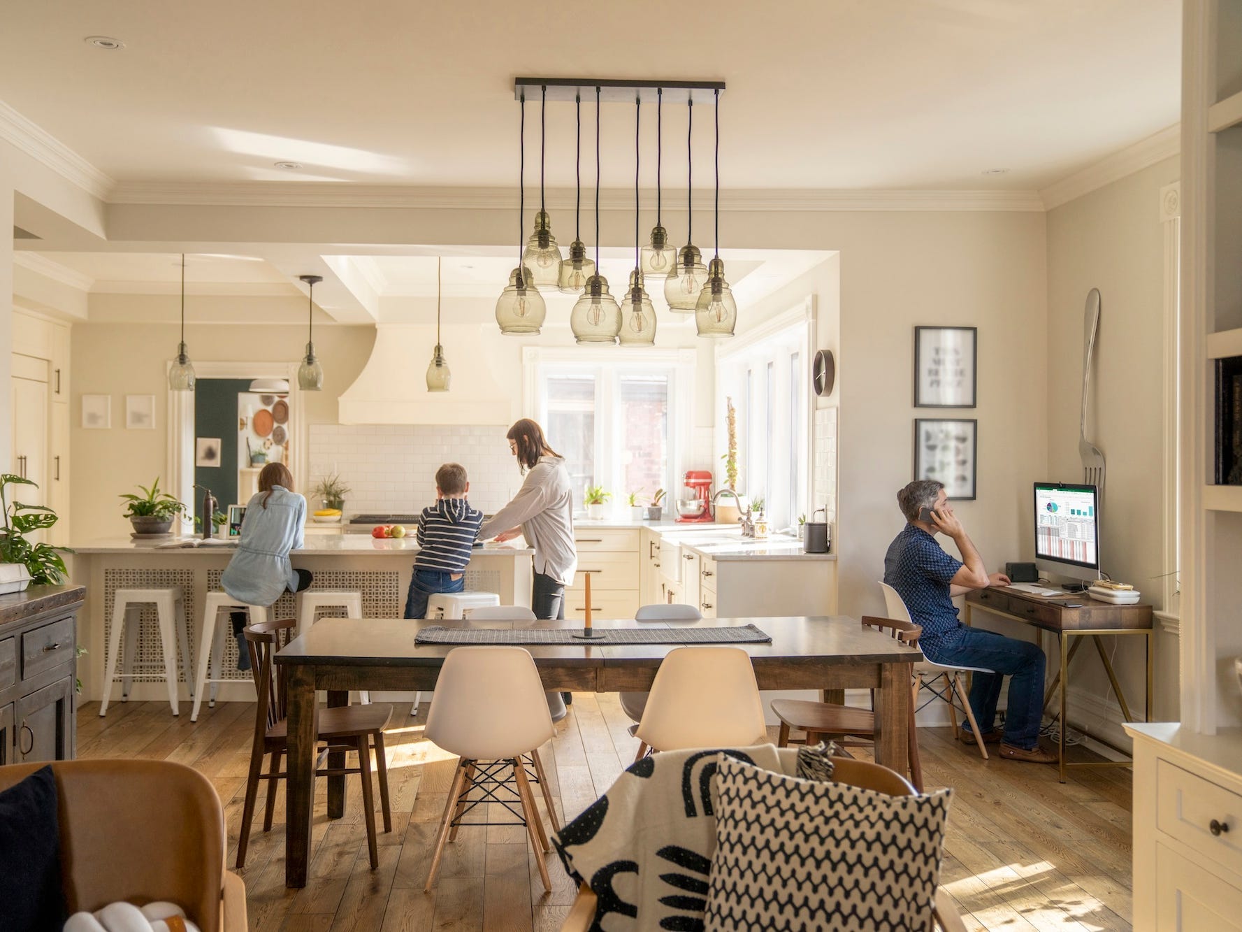 A family in an open concept home with a kitchen, dining, and living area.