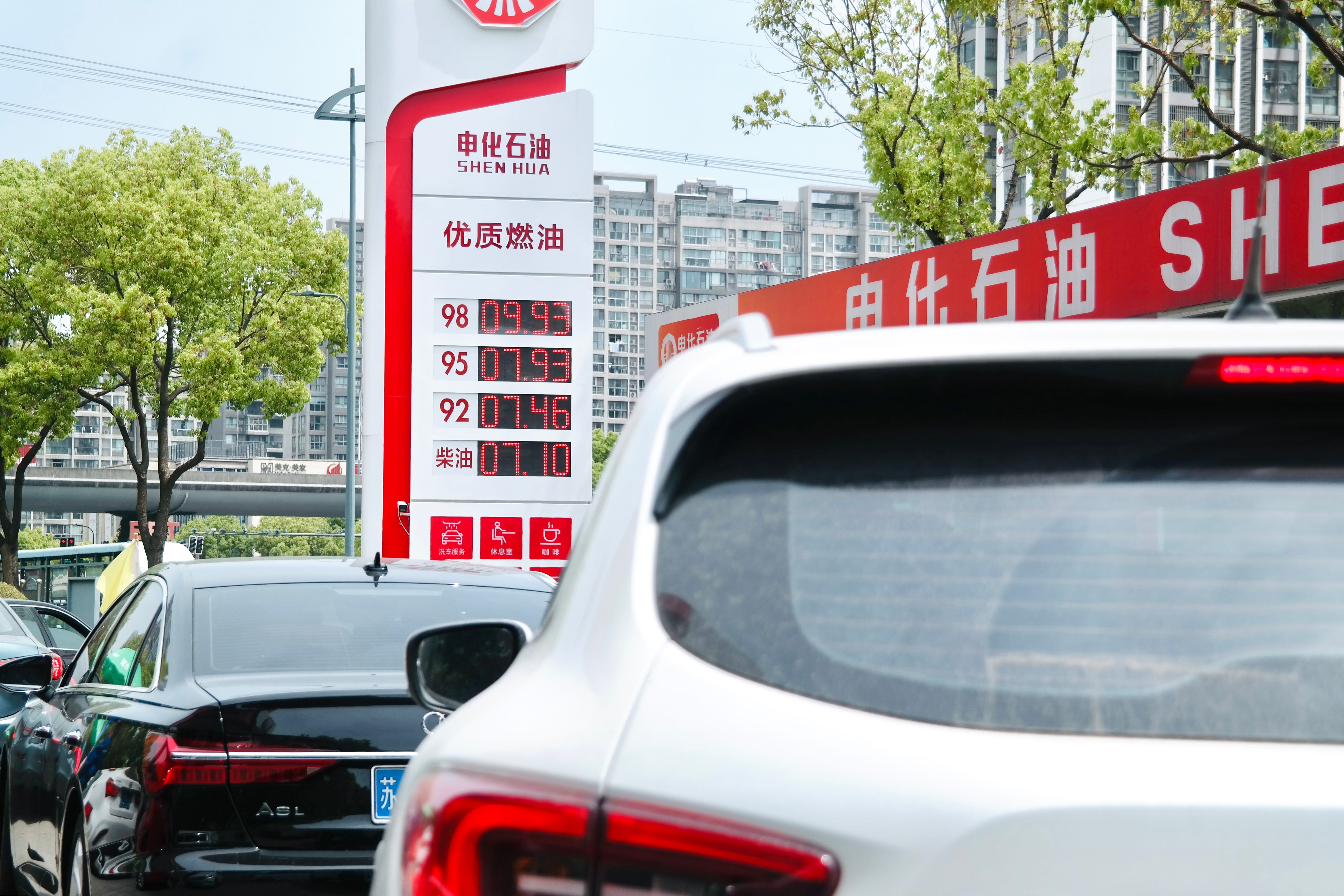 Cars run move past a fuel price display board at a gas station in Changzhou, Jiangsu Province of China.