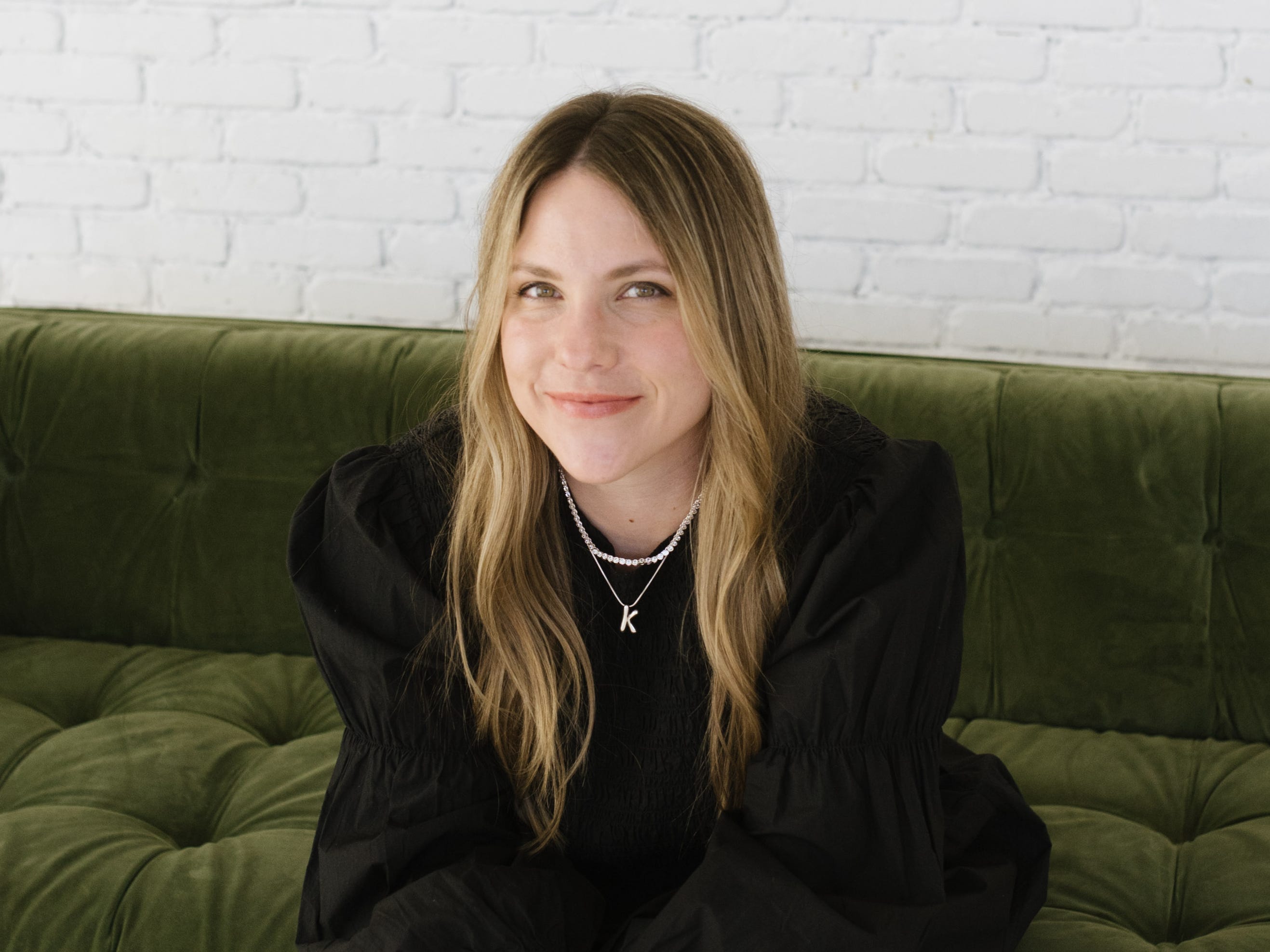blonde woman sitting on a green couch