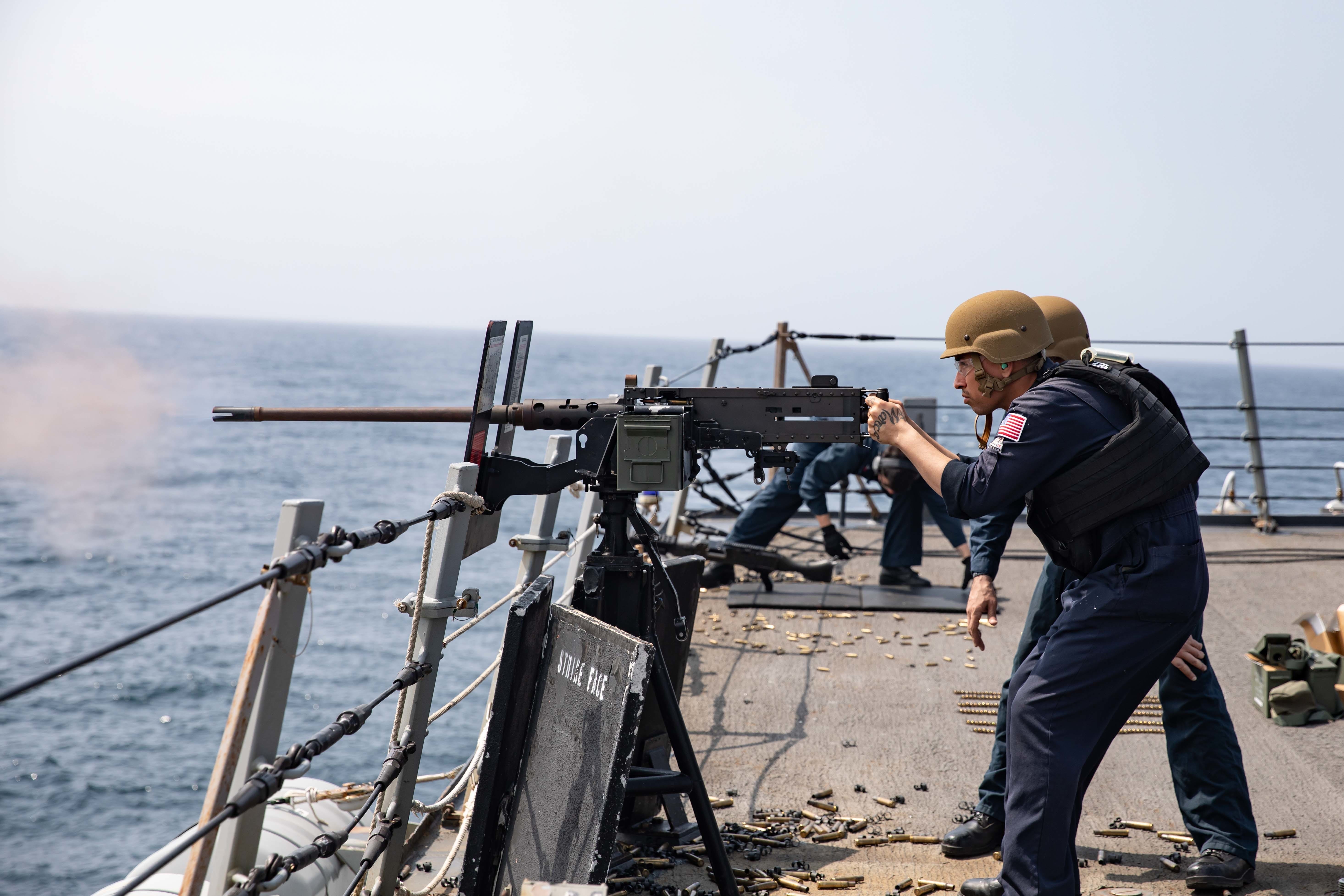 Personnel Specialist 2nd Class Mark Delacruz fires an M-2B .50 caliber machine gun aboard an Arleigh-Burke class guided-missile destroyer during a live-fire weapon training exercise, Feb. 25.