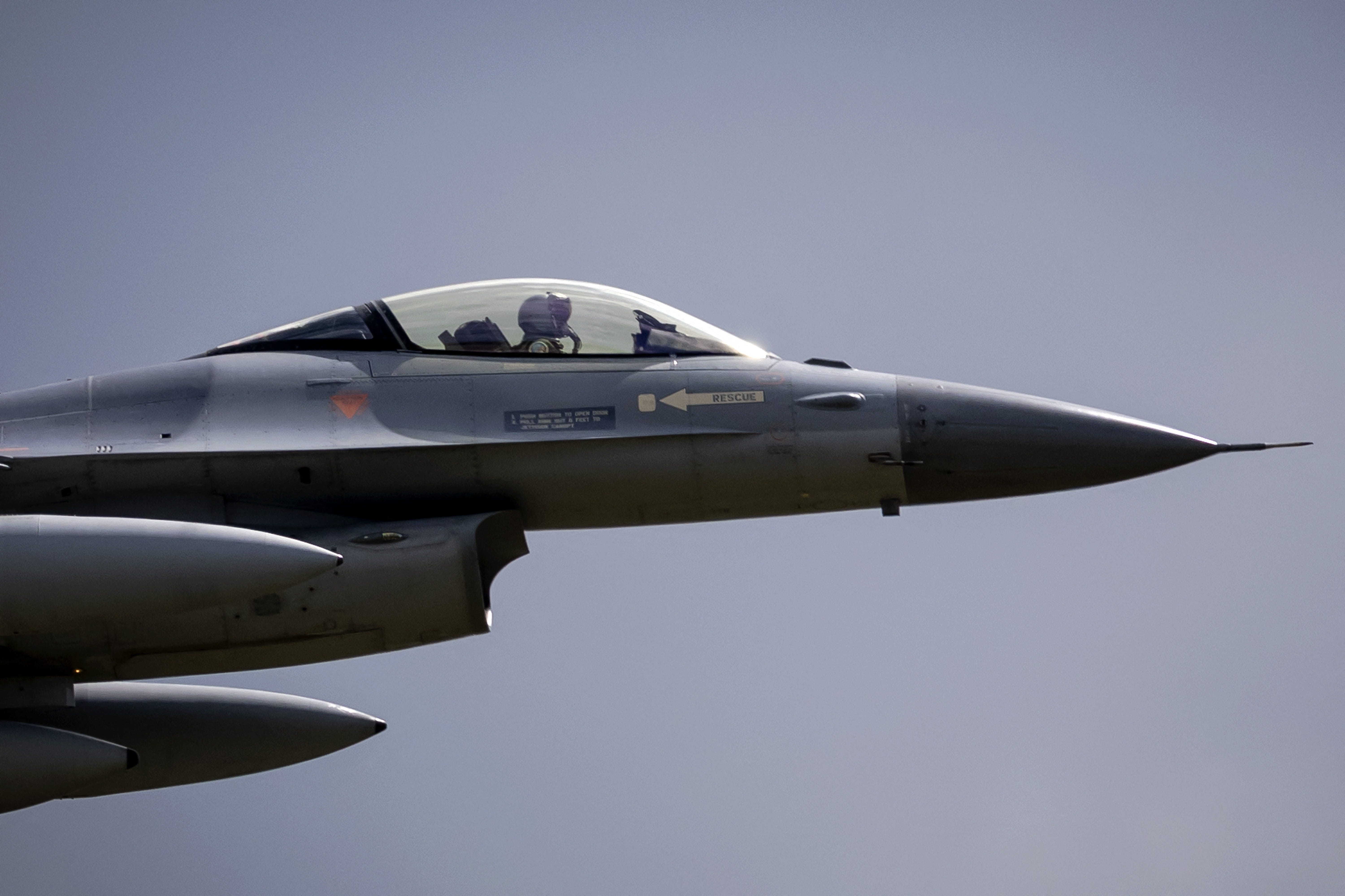 A pilot sits in the cockpit of an F-16.