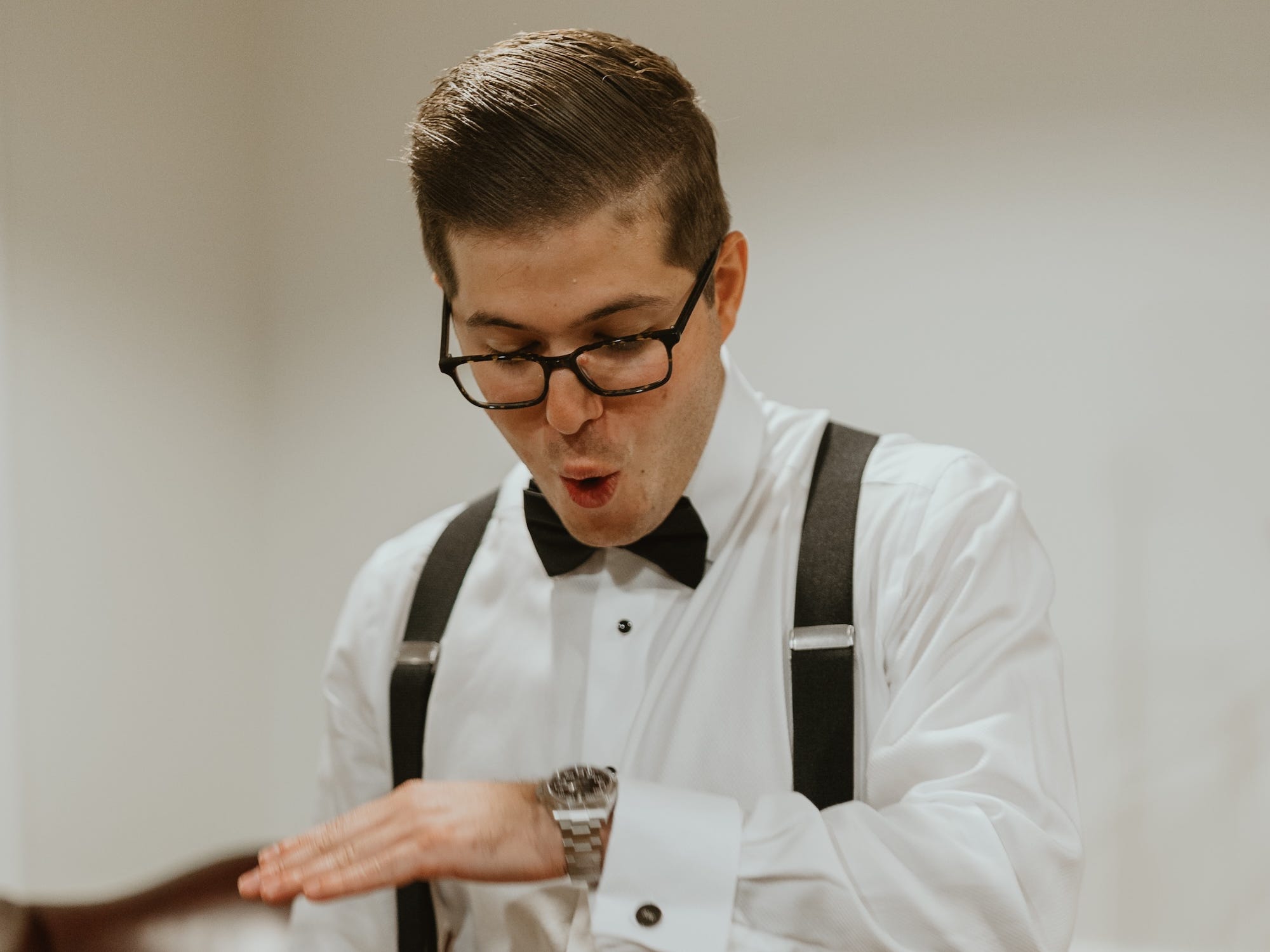 Andrew Woolf admires his Rolex watch on his wedding day.