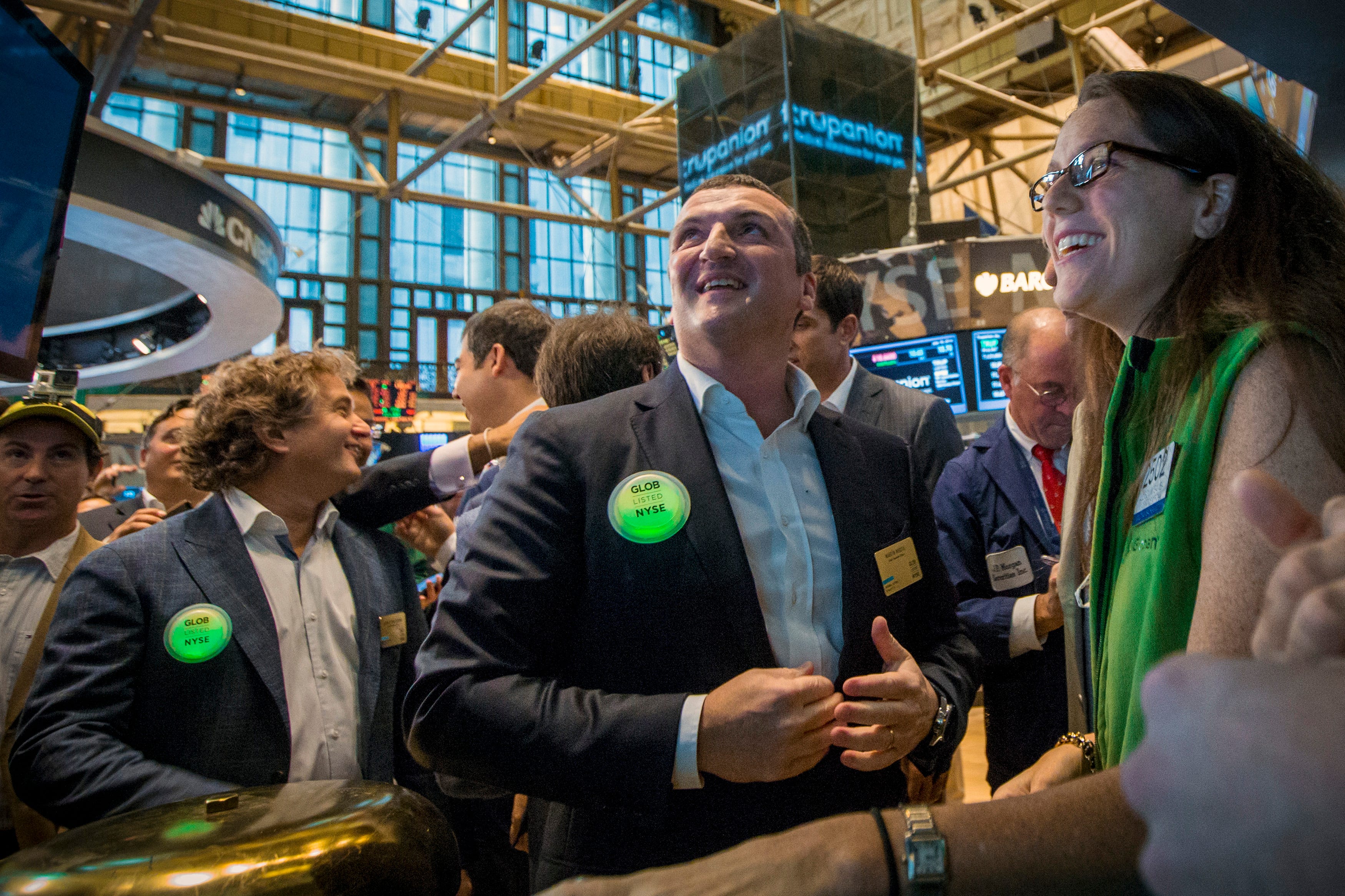 Globant CEO Martín Migoya (2nd R) checks the share price following his company's IPO celebration on the floor of the New York Stock Exchange July 18, 2014.