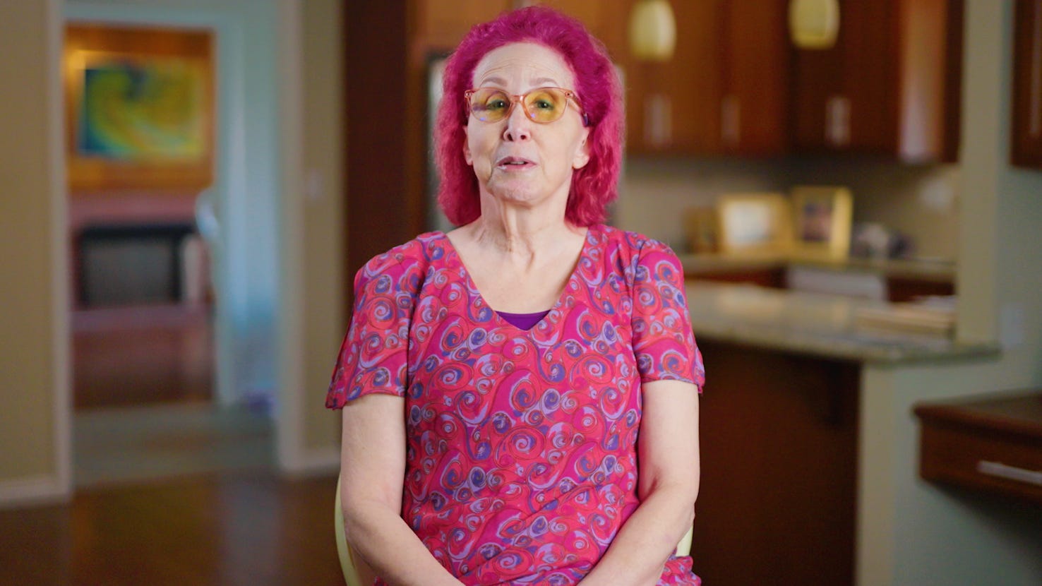 photo of woman in pink shirt with pink hair