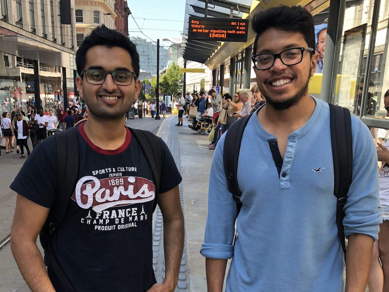 Archit Karandikar and Sanjeev Shenoy standing in front of a train station.