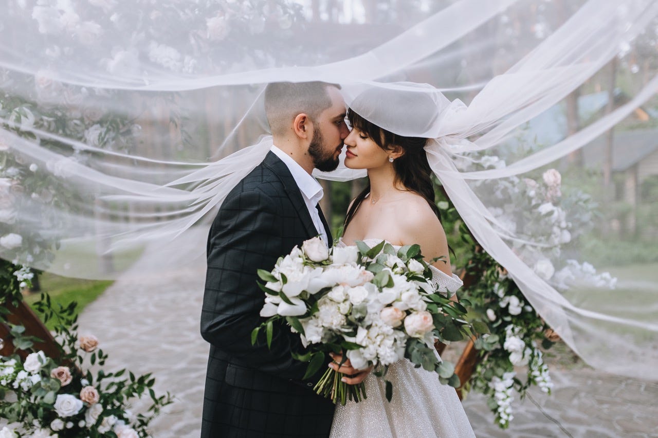 bride and groom kissing under veil