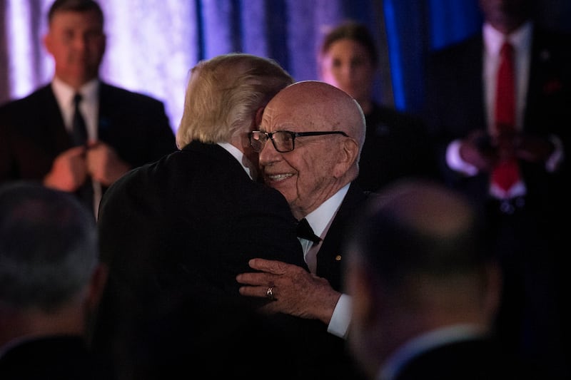 US President Donald Trump (L) is embraced by Rupert Murdoch, Executive Chairman of News Corp, during a dinner to commemorate the 75th anniversary of the Battle of the Coral Sea during WWII onboard the Intrepid Sea, Air and Space Museum May 4, 2017 in New York, New York. / AFP PHOTO / Brendan Smialowski (Photo credit should read BRENDAN SMIALOWSKI/AFP via Getty Images)