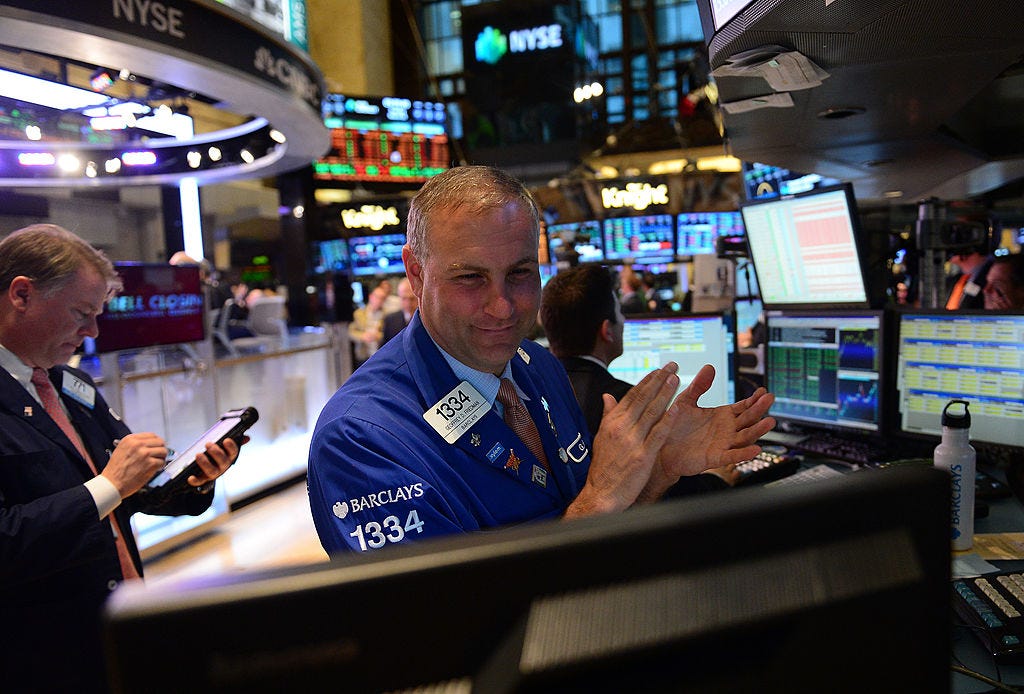 A stock trader claps at the end of trade at the New York Stock Exchange