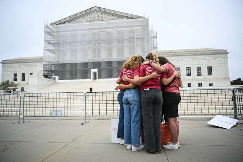 A group of women pray outside the Supreme Court, on the final day of the Court's term as the court was set to issue a decision on the case involving birthright citizenship.